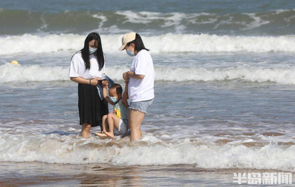 當天,記者在石老人海水浴場看到,部分遊客在海邊戲水,感受一下涼爽的