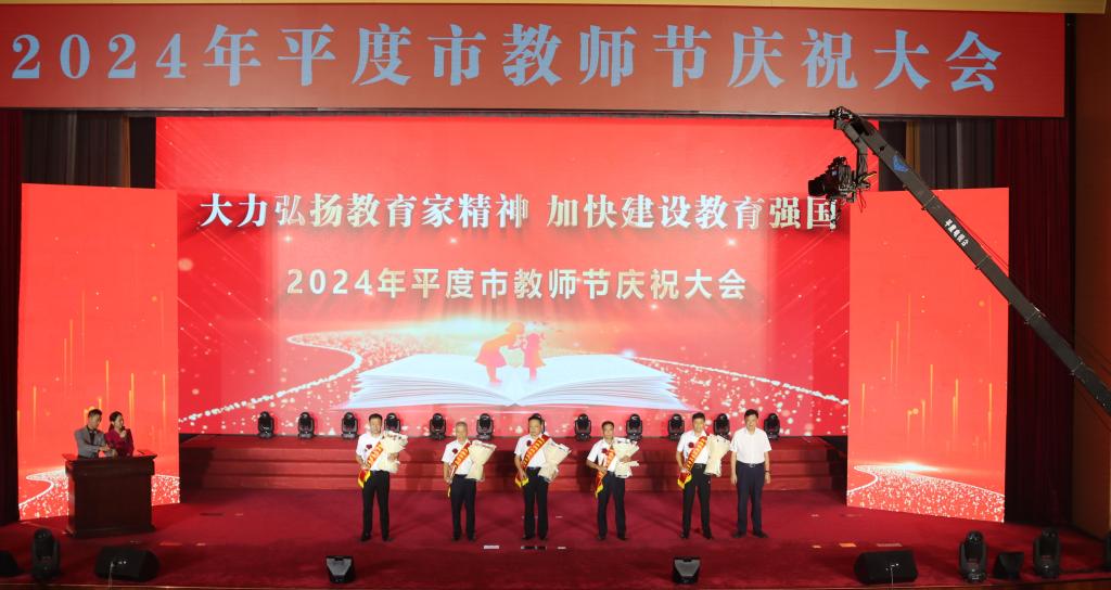 平度市人大常委会党组书记生辉为光荣在岗40年优秀园丁代表颁奖。